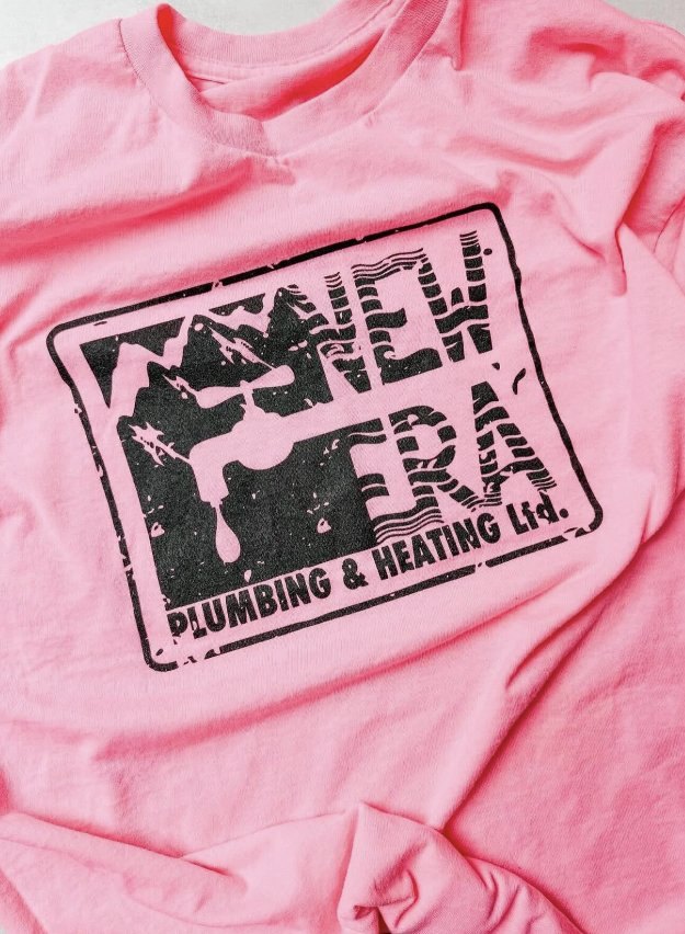 Pink New Era Plumbing & Heating t-shirt with the black stamp logo