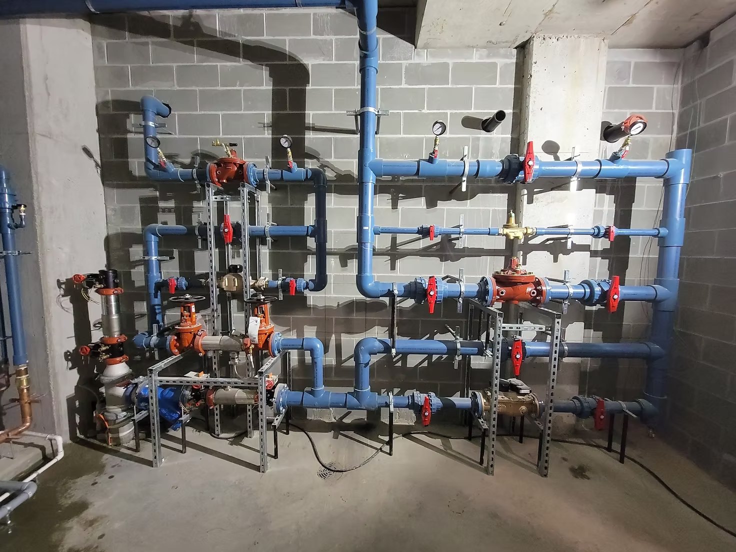 Blue and red water piping with valves in a commercial mechanical room