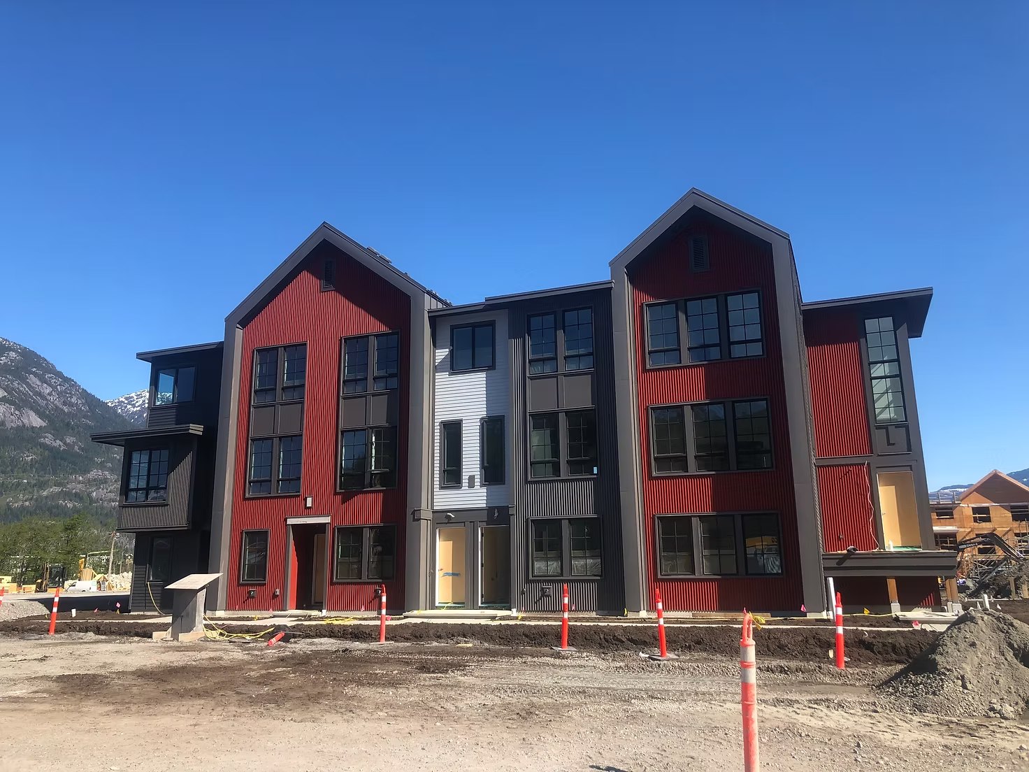 Red and grey townhomes at Sea and Sky with mountains behind